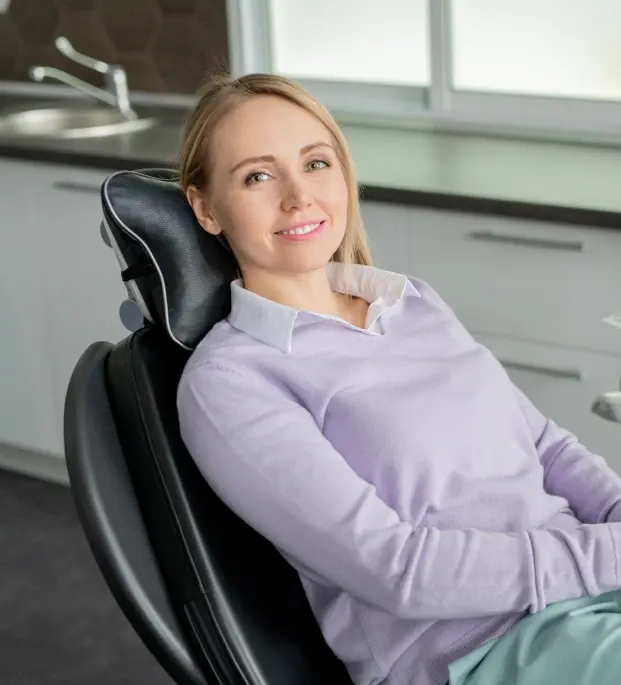Smiling woman in dental office chair at Netcong, NJ practice welcoming new patients.