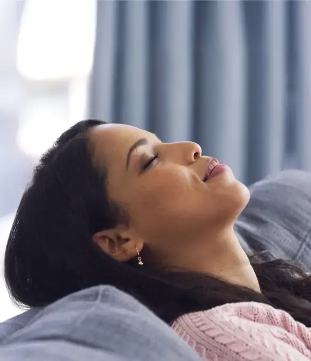 Woman relaxing with eyes closed during sleep apnea treatment at dental practice.